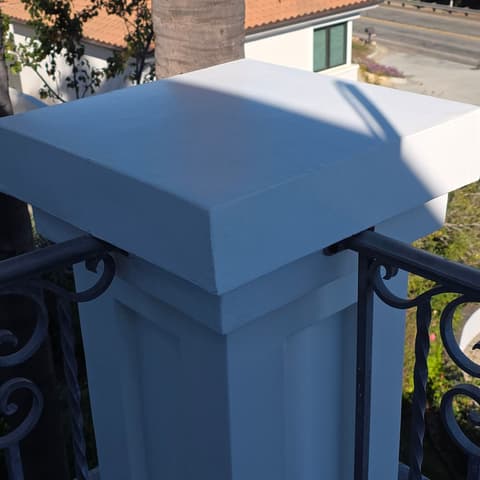 A white balcony pillar cap cleaned of dirt and droppings
