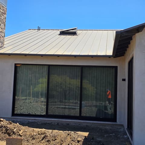 Sliding glass doors beside a stone chimney on a new build, the glass cleaned